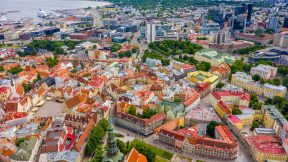 Aerial view of the old town of Tallinn with orange roofs and narrow streets below.